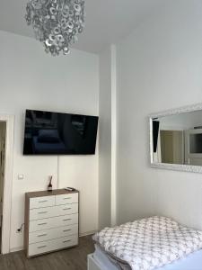 a bedroom with a bed and a dresser and a mirror at City Appartement in Hannover