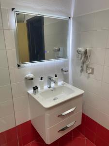 a bathroom with a white sink and a mirror at Cozy City Studio in Gjirokastër +11 photos