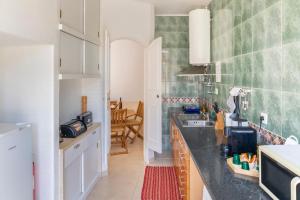 una cucina con un lavello e un piano di lavoro di DuplexduBocage a Setúbal