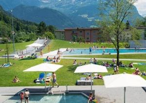 a group of people sitting around a swimming pool at Paradise mit Seesicht in Fluelen