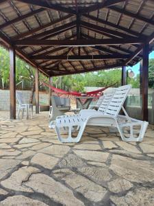 two white lounge chairs sitting under a pavilion at Refúgio GRUPOS com piscina, churrasqueiras 38 min Águas Claras Brasília in Brasília