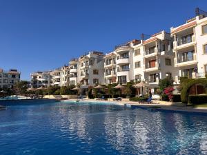 a swimming pool in front of some apartment buildings at Sharm Hills Resort - 2Bedroom with Pool View and Beach Access in Sharm El Sheikh
