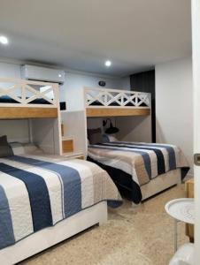 two bunk beds in a room with a table at Paraiso Azul in Acapulco