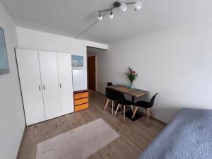 a room with a table and a kitchen with white cabinets at Zentrale 1-Zimmer-Wohnung Marzili Bern in Bern