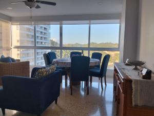 a dining room with a table and chairs and windows at Paraiso Azul in Acapulco