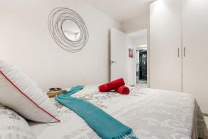 a bedroom with a white bed with a red object on it at Ines Luxury Costa Adeje in Adeje +43 photos