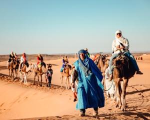 a group of people riding horses in the desert at Dar Menorca in Merzouga