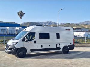 a white van parked in a parking lot at Camper La Palma fianza 600eu in Santa Cruz de la Palma