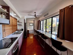 a kitchen with a long counter with chairs in it at Rainbow North - Rainbow Beach in Rainbow Beach