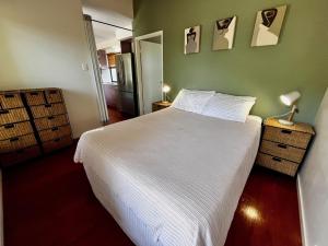 a bedroom with a white bed and a green wall at Rainbow North - Rainbow Beach in Rainbow Beach