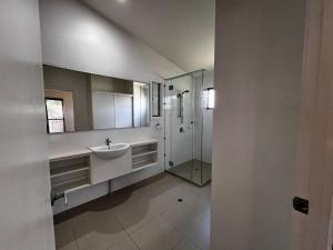 a white bathroom with a sink and a shower at Rainbow North - Rainbow Beach in Rainbow Beach +12 photos