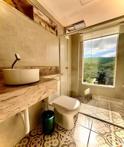 un bagno con lavandino, WC e finestra di Casa Miradouro do vale - Ar Condicionado nos dois quartos a Lençóis