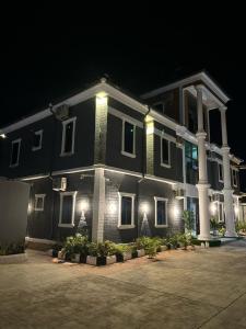 a large black house with white columns and lights at Grand T Abode Luxury Apartment in Ibadan