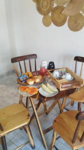 ein Holztisch mit Tellern voller Essen darauf in der Unterkunft Vila Malie milagres in São Miguel dos Milagres