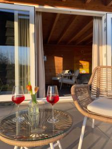 two glasses of wine sitting on a table on a patio at B&B Bed in Burgh in Burgh Haamstede +20 photos