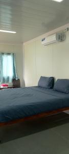 a bedroom with a large blue bed in a room at Anda Container House in Anda
