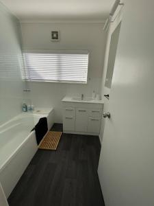 a white bathroom with a tub and a sink at Home away from Home in Hamilton +27 photos