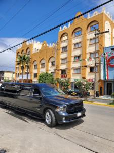 a limo parked on the street in front of a building at Hotel Posada de Santiago in Tijuana