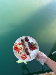 a person holding a plate with food on it at Apollon boat tour in Side