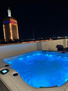 a hot tub on a balcony at night with a lighthouse at The Central guesthouse in Tal-Pietà