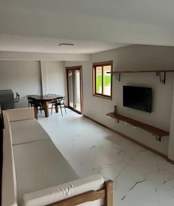 un soggiorno con un divano, una TV e un tavolo di Casa Miradouro do vale - Ar Condicionado nos dois quartos a Lençóis Altre 17 foto