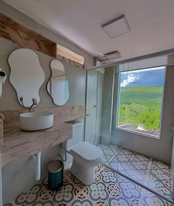 bagno con servizi igienici e ampia finestra. di Casa Miradouro do vale - Ar Condicionado nos dois quartos a Lençóis