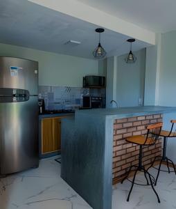 una cucina con bancone e 2 sgabelli da bar di Casa Miradouro do vale - Ar Condicionado nos dois quartos a Lençóis