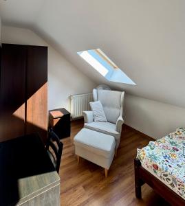 Una habitación abuhardillada con una silla y una cama. en Apartament Błękitny, en Krynica Morska 9 fotos más