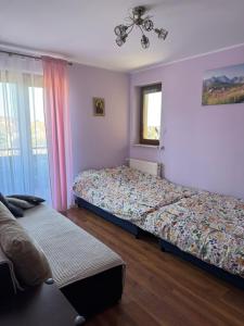 Un dormitorio con dos camas y una ventana. en Apartament Błękitny, en Krynica Morska