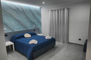 a bedroom with a blue bed with a painting on the wall at Affittacamere ONE in Frascineto