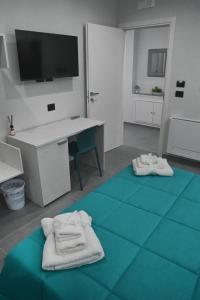 a room with a desk and towels on a blue floor at Affittacamere ONE in Frascineto