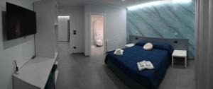a bedroom with a blue bed and a flat screen tv at Affittacamere ONE in Frascineto