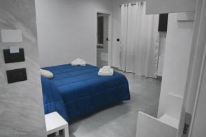 a bedroom with a blue bed in a white room at Affittacamere ONE in Frascineto