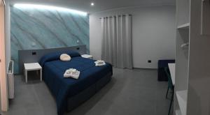 a bedroom with a blue bed with towels on it at Affittacamere ONE in Frascineto