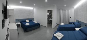 a bedroom with two blue beds and a living room at Affittacamere ONE in Frascineto