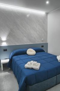 a bedroom with a blue bed with towels on it at Affittacamere ONE in Frascineto