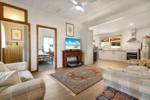 ein Wohnzimmer mit 2 Sofas und einer Küche in der Unterkunft Armstrong Cottage in Paynesville