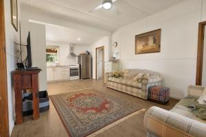 ein Wohnzimmer mit Couch und Küche in der Unterkunft Armstrong Cottage in Paynesville + 8 Fotos