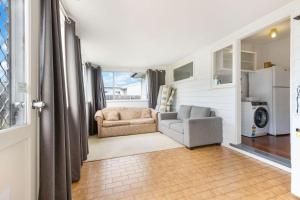 a living room with a couch and a chair at Shelby Cottage in Paynesville