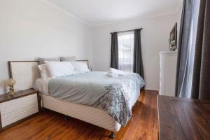 a white bedroom with a bed and a window at Shelby Cottage in Paynesville