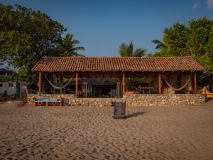 a building on a sandy beach with a building at Big Surf House in Popoyo