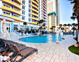 a swimming pool with chairs and a building at Wyndham Ocean Walk Resort 2332 - Vacation in Comfort and luxury - 2BR Oceanview in Daytona Beach