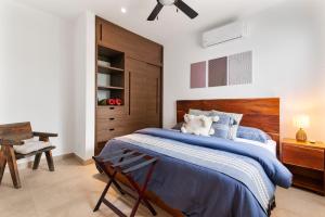 a bedroom with a blue bed with a wooden headboard at Encanto Private Balcony 2 Pools Gym Only 5 Minutes To Tulum Beaches in Tulum