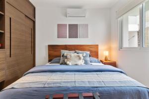 a bedroom with a large bed with a wooden headboard at Encanto Private Balcony 2 Pools Gym Only 5 Minutes To Tulum Beaches in Tulum
