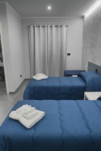 a room with two blue beds with towels on them at Affittacamere ONE in Frascineto