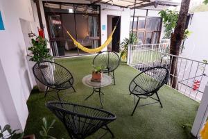 un patio con quattro sedie, un tavolo e un'amaca di Habitación privada con terraza y WiFi rápido en el centro ad Asunción