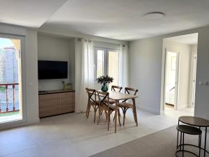 Un comedor con mesa y sillas y un televisor. en Apartamento El Olivo, en Noja