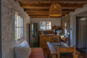 eine Küche mit Holztisch und Kühlschrank in der Unterkunft Casa Campo 1931 in Colonia del Sacramento