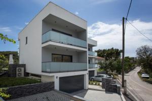 a white house with a glass facade at Villa Tesa 2 in Okrug Donji