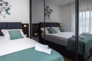 a bedroom with two beds and a mirror at Villa Tesa 2 in Okrug Donji +23 photos